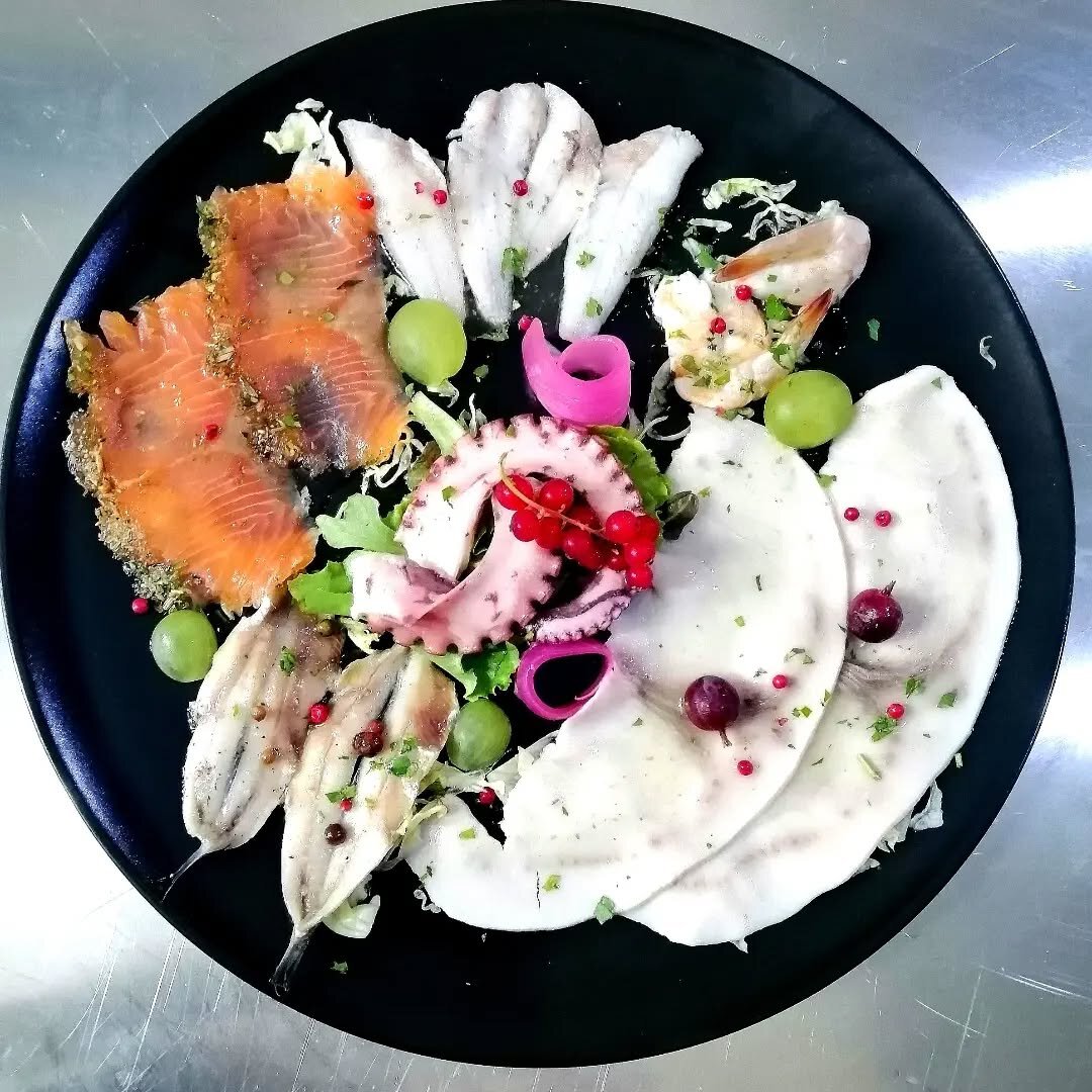 Selezione di salumi di mare su piatto nero